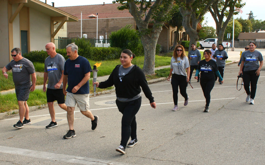 Image for display with article titled Officers Help Carry Special Olympics Torch Through King City