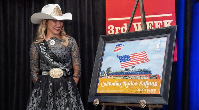 Woman stands next to rodeo poster