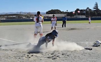 Softball player slides home