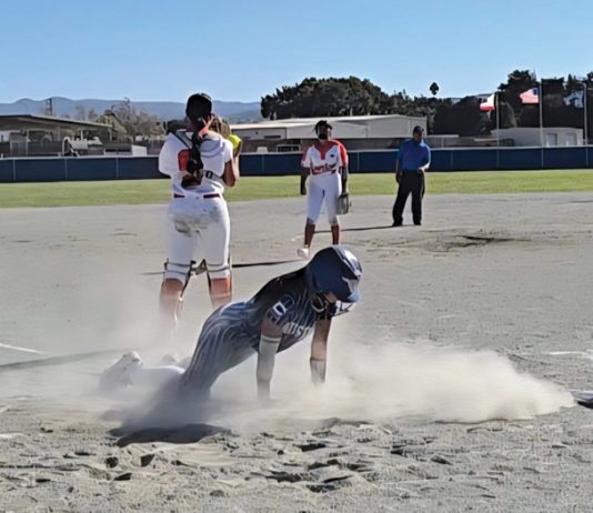 Softball player slides home