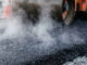 King City begins pavement rehabilitation project Heavy industrial steamroller machine pressing hot, steaming black asphalt during road construction