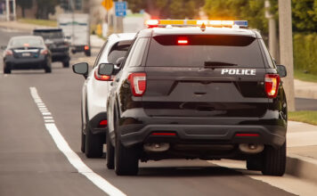 Behind view of a police car that pulled a motorist over to the side of the road