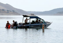 Dive team members and park rangers search lake