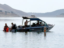 Dive team members and park rangers search lake