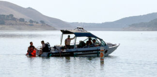 Dive team members and park rangers search lake