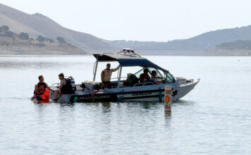 Dive team members and park rangers search lake