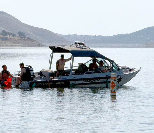 Dive team members and park rangers search lake