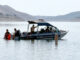 Dive team members and park rangers search lake